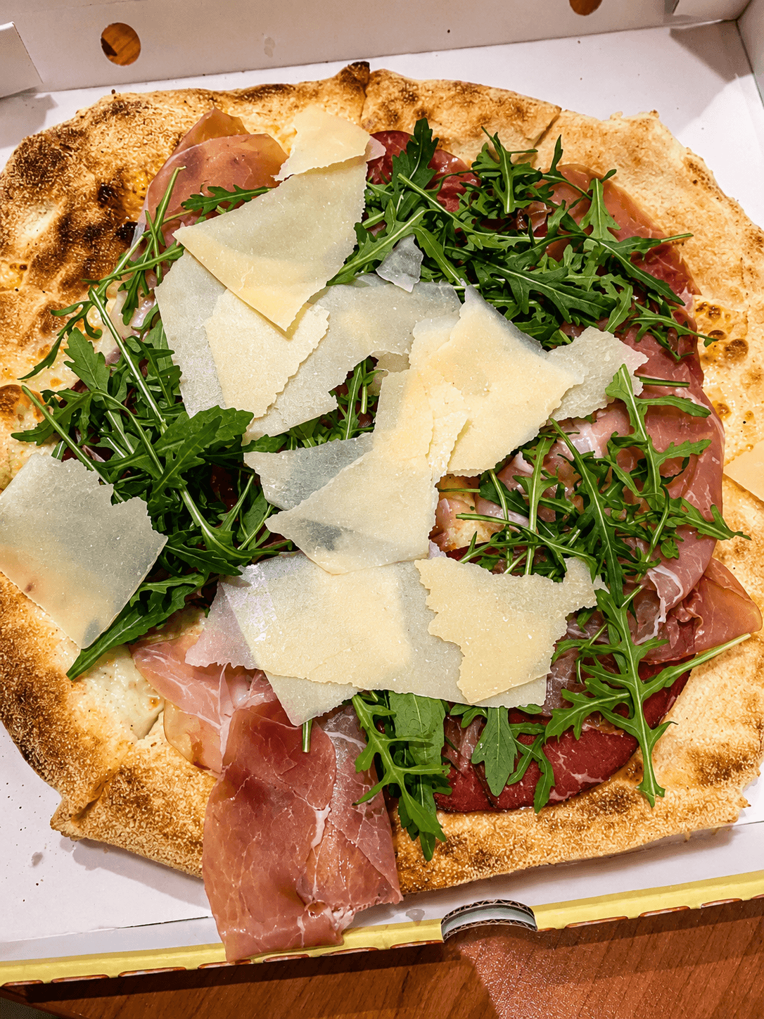 Pizza prosciutto crudo, roquette et copeaux de parmesan